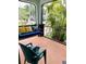 Relaxing screened porch featuring a comfortable porch swing and a view of lush greenery at 214 Scotland St, Dunedin, FL 34698