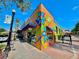A brightly painted building corner, street lamp, sidewalk, and view of retail storefronts at 214 Scotland St, Dunedin, FL 34698