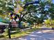 Streetscape featuring a Dunedin sign, colorful storefronts, and a tree-lined path, showing a welcoming community at 214 Scotland St, Dunedin, FL 34698