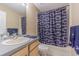 Well-lit bathroom with a sink, toilet, and a shower featuring a Penn State-themed curtain at 2146 Gold Dust Ct, Trinity, FL 34655