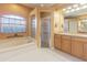 Bright bathroom featuring a soaking tub, glass enclosed shower, and vanity with a granite countertop at 2146 Gold Dust Ct, Trinity, FL 34655