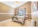 Cozy bedroom featuring a vaulted ceiling, large window, and neutral decor at 2146 Gold Dust Ct, Trinity, FL 34655