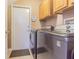 Functional laundry room with a modern washer and dryer set, cabinets, and a convenient door at 2146 Gold Dust Ct, Trinity, FL 34655