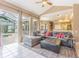 Open-concept living room with tile flooring, large sectional sofa, and sliding glass doors to the pool area at 2146 Gold Dust Ct, Trinity, FL 34655
