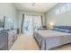 Serene bedroom with a king-size bed, dresser, and sliding glass doors to the screened-in lanai at 2146 Gold Dust Ct, Trinity, FL 34655