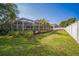 A spacious backyard featuring manicured lawn and screened-in patio at 2507 Dewberry St, Valrico, FL 33596