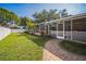 Backyard featuring lush lawn, brick pavers, white fence and screened patio at 2507 Dewberry St, Valrico, FL 33596