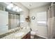 Well-lit bathroom with granite counters, large mirror, and shower-tub combination, offering a clean, functional design at 2507 Dewberry St, Valrico, FL 33596