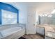 Bathroom boasting a soaking tub, double vanity sinks, and modern lighting fixtures at 2507 Dewberry St, Valrico, FL 33596