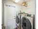 Convenient laundry room featuring modern washer and dryer, storage shelves, and easy access to exterior door at 2507 Dewberry St, Valrico, FL 33596