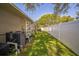 Spacious side yard with lush green lawn and white privacy fence at 2507 Dewberry St, Valrico, FL 33596