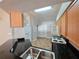Bright eat-in kitchen with wood cabinets, black countertops, and essential appliances at 2614 Queen Alberta Dr, Valrico, FL 33594
