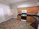 Functional kitchen with wood cabinets, black countertops, and essential appliances at 2614 Queen Alberta Dr, Valrico, FL 33594