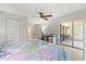 Bright bedroom with a ceiling fan, desk and an access to the balcony with a sliding door at 2650 Countryside Blvd # A210, Clearwater, FL 33761