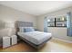 Clean bedroom with wooden floors and a large window with natural light. The room has a gray bed frame at 2650 Countryside Blvd # A210, Clearwater, FL 33761