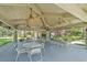 Community clubhouse featuring a shaded seating area with ceiling fans and tables at 2650 Countryside Blvd # A210, Clearwater, FL 33761