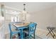 Charming dining area features a wooden table with blue chairs and decorative light fixture at 2650 Countryside Blvd # A210, Clearwater, FL 33761