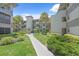 Condo complex exterior showcasing courtyard, manicured landscaping, and walkways at 2650 Countryside Blvd # A210, Clearwater, FL 33761