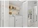 Bright laundry room area with washer, dryer and wire rack shelving unit at 2650 Countryside Blvd # A210, Clearwater, FL 33761