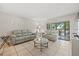 Bright living room with tile floors, neutral sofas, and sliding glass doors to the outside at 2650 Countryside Blvd # A210, Clearwater, FL 33761
