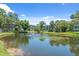 Scenic view of community pond with fountain, surrounded by lush landscaping and residential buildings at 2650 Countryside Blvd # A210, Clearwater, FL 33761