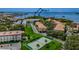 Scenic aerial view of condo community with lush landscaping, tennis court, and waterfront access at 2700 Bayshore Blvd # 5210, Dunedin, FL 34698