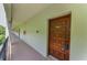 Condo exterior entryway featuring a secure wooden door with unit number and well-maintained walkway at 2700 Bayshore Blvd # 5210, Dunedin, FL 34698