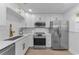 Modern kitchen featuring white cabinets, stainless steel appliances, and a stylish sink faucet at 2700 Bayshore Blvd # 5210, Dunedin, FL 34698