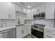 Well-lit kitchen featuring white cabinets, stainless steel appliances, and modern fixtures at 2700 Bayshore Blvd # 5210, Dunedin, FL 34698