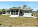 View of the backyard featuring lush green grass and a screened patio area at 2826 Martha Ln, Land O Lakes, FL 34639