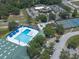 Aerial view of a community pool, tennis courts, and parking lot at 2826 Martha Ln, Land O Lakes, FL 34639