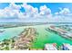 Picturesque aerial view featuring charming waterfront homes, boats, and vibrant waterways under fluffy clouds at 301 S Gulfview Blvd # 301, Clearwater Beach, FL 33767