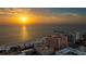 Panoramic view of the beach with hotels, condos, and a bright sunset at 301 S Gulfview Blvd # 301, Clearwater Beach, FL 33767