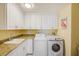Functional laundry room with front-loading washer and dryer, and utility sink at 301 S Gulfview Blvd # 301, Clearwater Beach, FL 33767