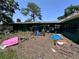 Backyard of a single story home featuring various objects scattered around the lawn at 314 Dickman Sw Dr, Ruskin, FL 33570