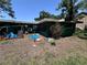 Backyard of a single story home featuring various objects scattered around the lawn at 314 Dickman Sw Dr, Ruskin, FL 33570