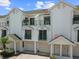 Townhome features multiple stories, individual garages, and balconies with green metal railings at 320 Island Way # 205, Clearwater Beach, FL 33767