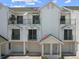 Bright, multi-level exterior shows balconies, doors, and garages against a brilliant sky at 320 Island Way # 205, Clearwater Beach, FL 33767
