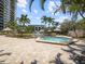 Inviting community spa surrounded by landscaping, poolside seating, and palm trees at 320 Island Way # 205, Clearwater Beach, FL 33767