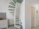 Spiral staircase with green carpet leading to the upper floor near a chest of drawers at 320 Island Way # 205, Clearwater Beach, FL 33767