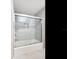 Modern bathroom features a tub with gray tile surround and sliding glass door at 345 Bayshore Blvd # 1813, Tampa, FL 33606