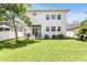 A view of the well-maintained backyard with lush green grass and a white two-story home at 3616 W Anderson Ave, Tampa, FL 33611