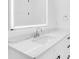 Bathroom with a large, lighted mirror above a white vanity with marble countertops at 3616 W Anderson Ave, Tampa, FL 33611