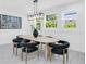 Bright dining room features a modern light fixture, an oval dining table, and comfortable chairs with views of the outside greenery at 3616 W Anderson Ave, Tampa, FL 33611