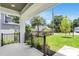 Covered front porch featuring white tile flooring, iron railings, and views of the landscaped front yard at 3616 W Anderson Ave, Tampa, FL 33611