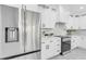 Modern kitchen with stainless steel refrigerator, range, white cabinetry, and sleek countertops at 3616 W Anderson Ave, Tampa, FL 33611