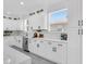 Modern kitchen featuring white cabinetry, quartz countertops, stainless steel appliances, and bright natural light at 3616 W Anderson Ave, Tampa, FL 33611
