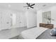 Spacious bedroom featuring gray wood-look floors, a decorative cabinet, and access to the bathroom via white doors at 3616 W Anderson Ave, Tampa, FL 33611