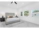 Bright bedroom features a gray upholstered headboard, views from the windows, and sleek bedside lamps on the black bedside tables at 3616 W Anderson Ave, Tampa, FL 33611