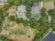 This aerial shot offers mature landscaping, the parking lot, and the basketball and volleyball courts at 4320 Auston Way, Palm Harbor, FL 34685